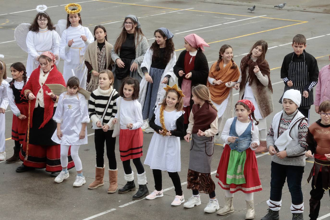 Ancianos observan a los alumnos interpretar el belén viviente.