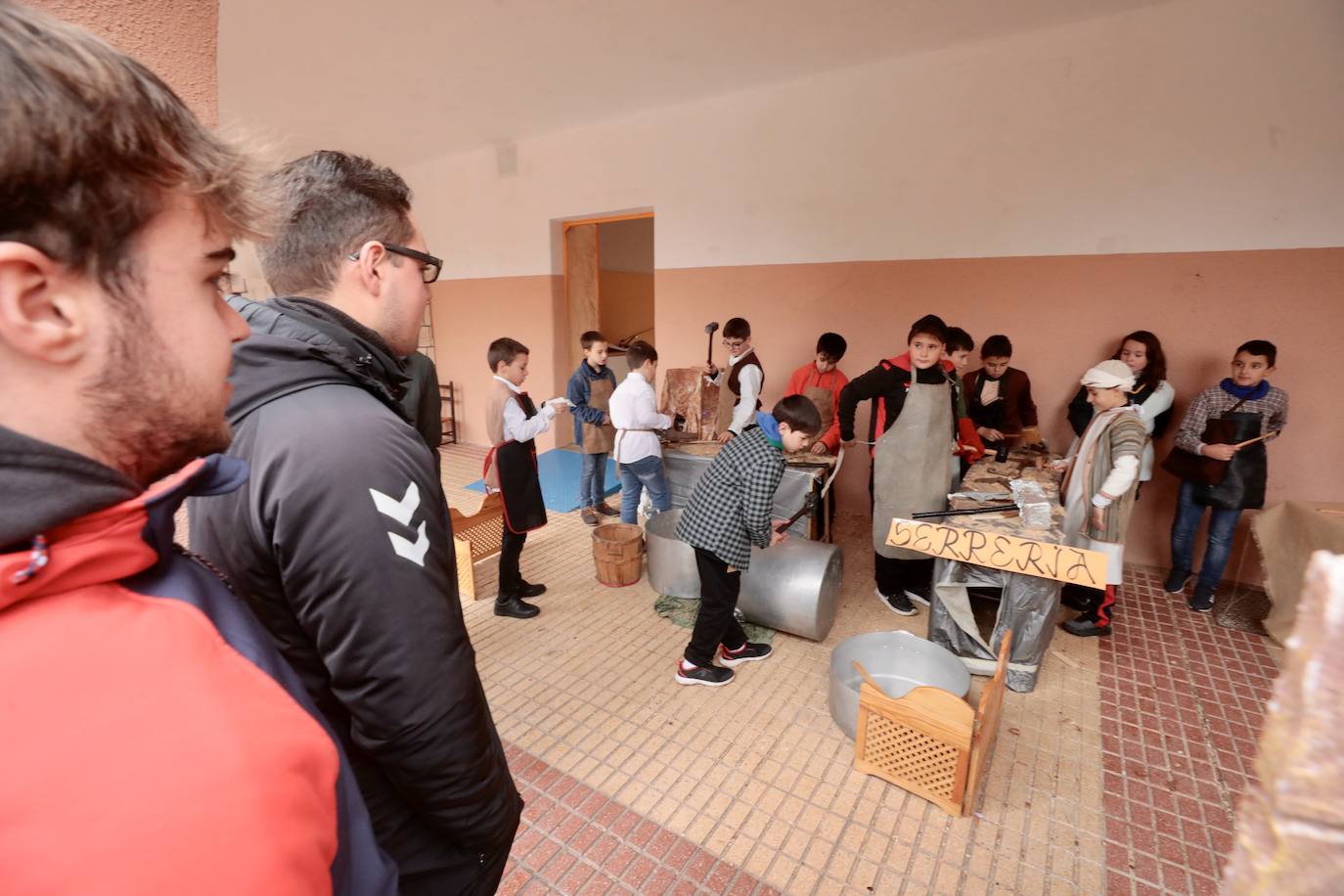 Ancianos observan a los alumnos interpretar el belén viviente.