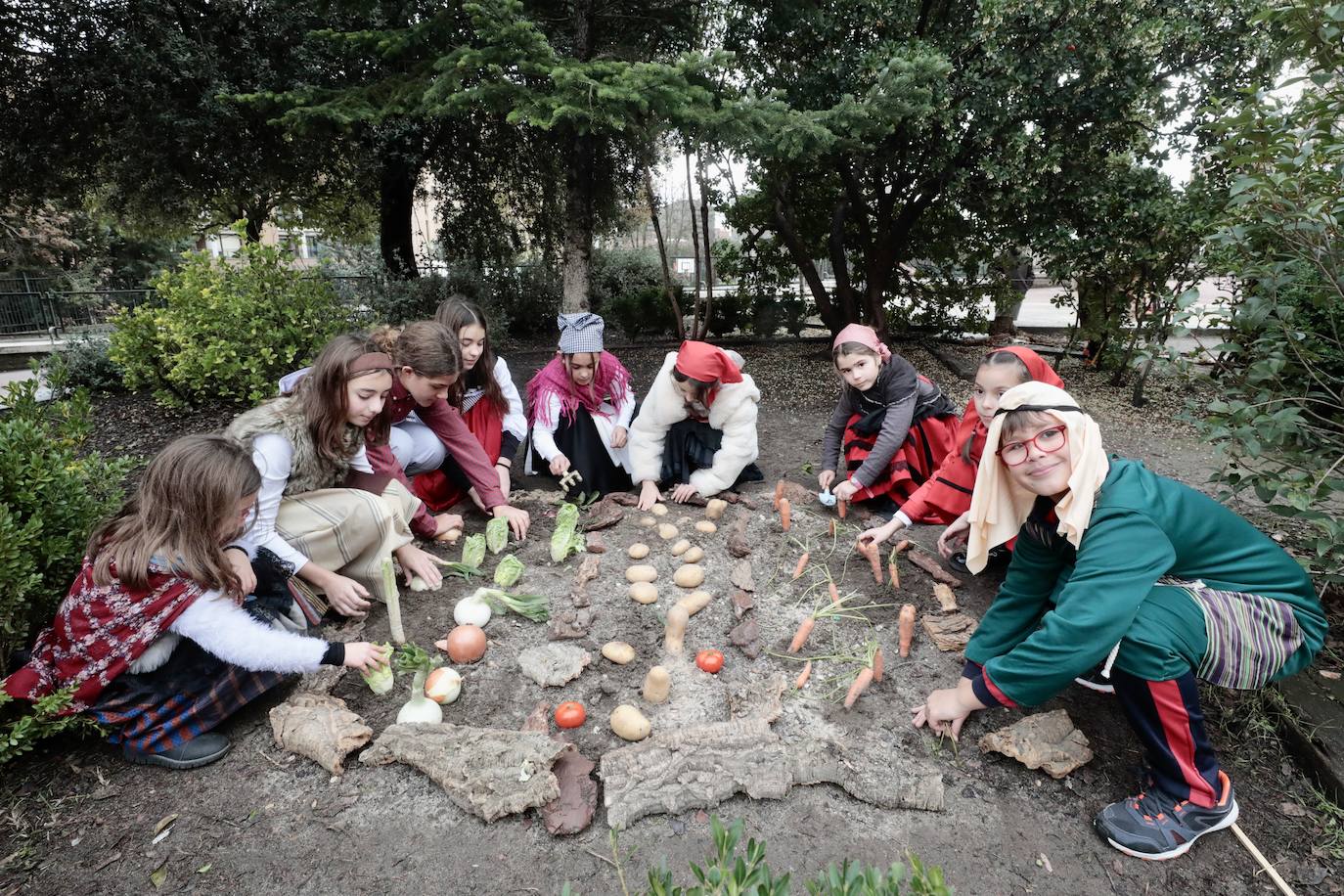 Ancianos observan a los alumnos interpretar el belén viviente.
