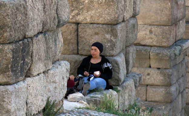 Una mujer come en el Acueducto de Segovia. 