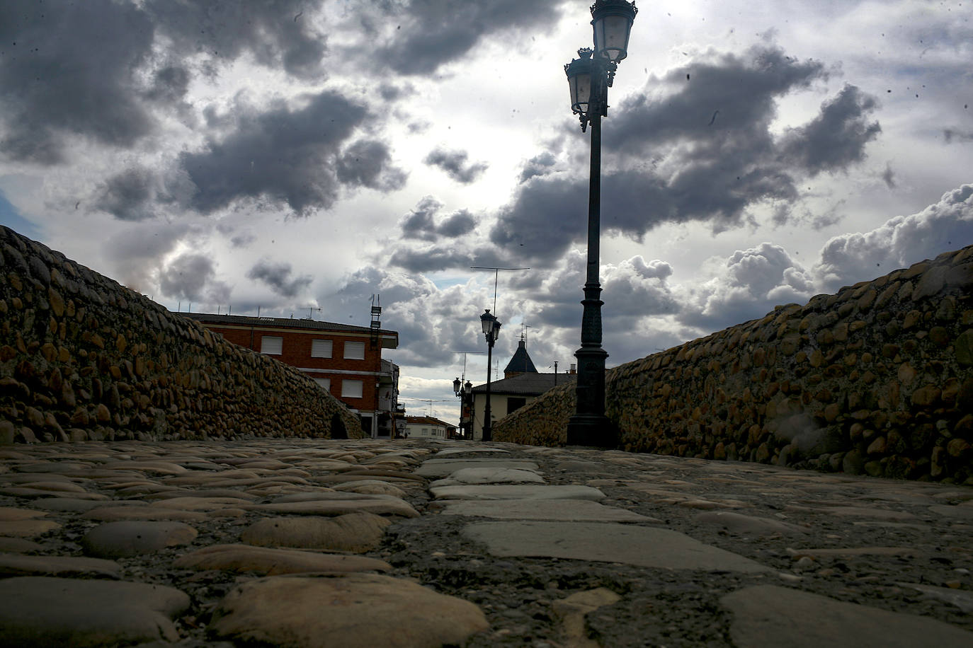 La imagen refleja el cielo enfurecido atravesando el puente de Hospital de Orbigo.