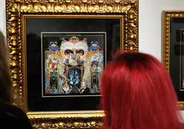 Una mujer observa la portada del disco 'Dangerous', de Michael Jackson, obra de Mark Ryden que se expone en Valladolid.