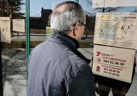 Un hombre lee los horarios del edificio de la Seguridad Social de la calle Sajambre.