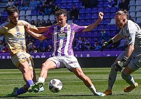 Un futbolista del Palencia intenta batir al meta del Real Valladolid Promesas.