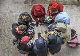 Un grupo de adolescentes con sus teléfonos móviles