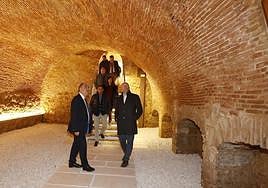 El delegado de la Junta y el alcalde de Paredes observan la bodega del convento, ya restaurada y sin humedades.
