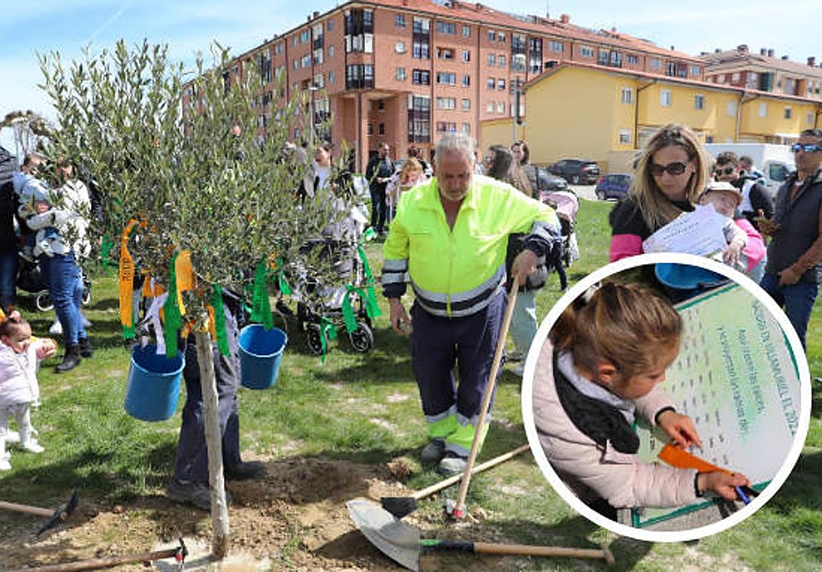 Las familias, junto al árbol del que cuelgan lazos con los nombres. En el círculo, una pequeña observa los nombres de los nacidos en 2022.