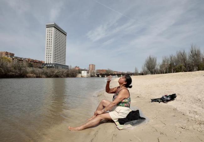 Una mujer se refresca a orillas del Pisuerga en la playa de Las Moreras.