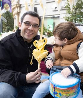 Imagen secundaria 2 - Arriba, Diana Mongil en su puesto de la Plaza España. A la izquierda, Rosa María A. García vende una palma a una abuela. A la derecha, Javier y su hijo Adrián tras comprar una palma en la calle Santiago.