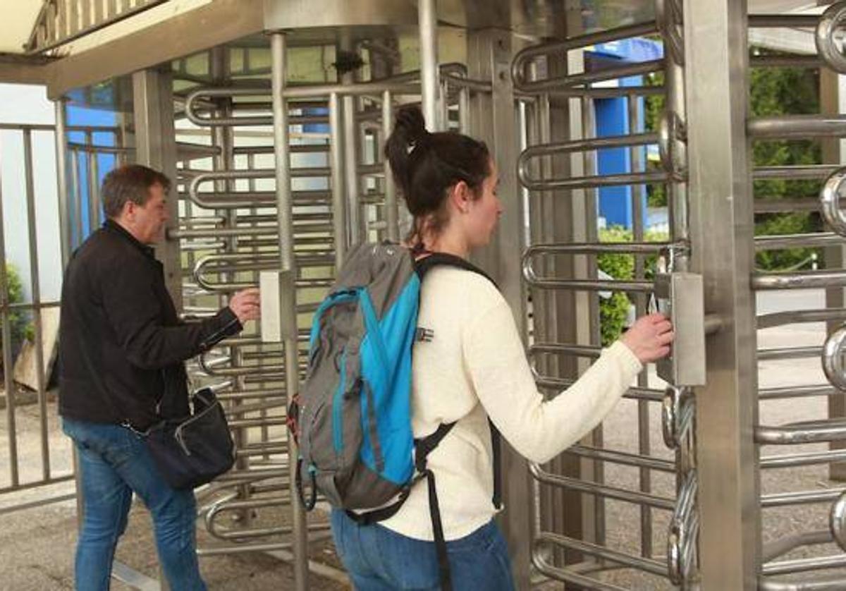 Dos trabajadores se registran antes de iniciar la jornada laboral.