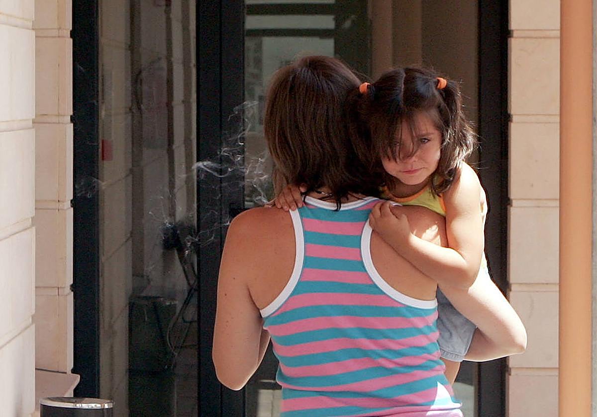 Una madre lleva a su hija en brazos a un centro de salud de la provincia.