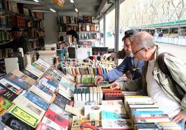 Clientes miran uno de los puestos de la Feria del Libro Antiguo y de Ocasión de Valladolid.