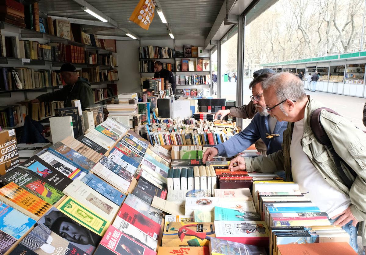 Clientes miran uno de los puestos de la Feria del Libro Antiguo y de Ocasión de Valladolid.