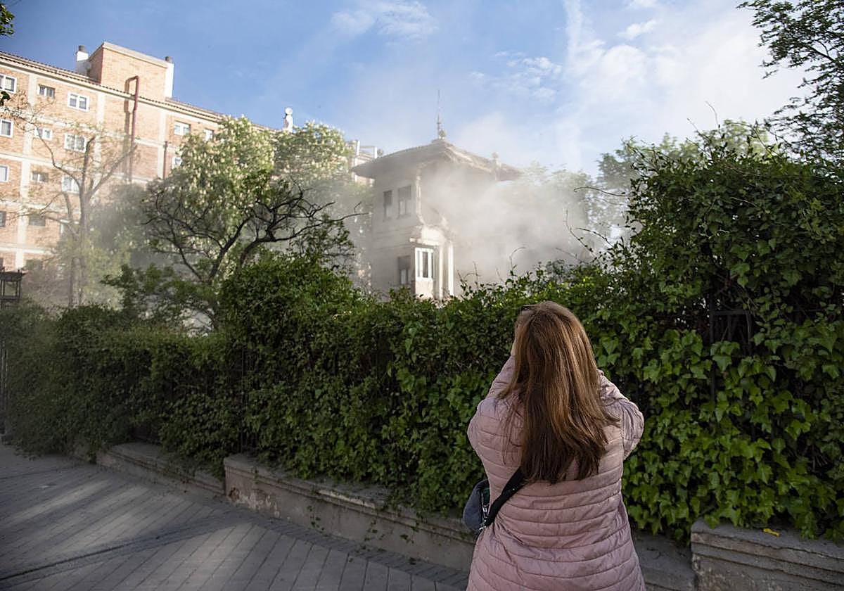 Una mujer fotografía del derribo del chalé de Villa Estrella.