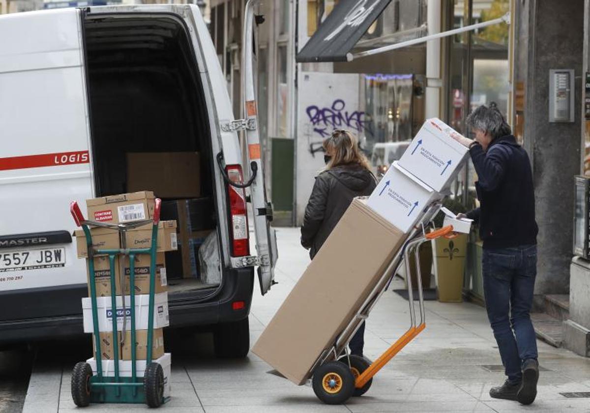 Un repartidor carga paquetes en una furgoneta.