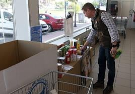 Un hombre coloca los productos en un punto de recogida de Palazuelos del Eresma.