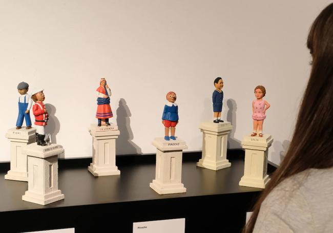 Una mujer mira la reproducción de las estatuas infantiles de Poniente.