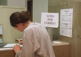 Una joven solicita el voto por correo en una oficina.