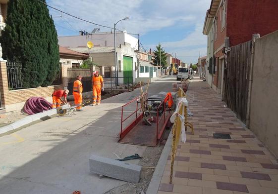 Los operarios rematan el adoquinado de las aceras de la calle Azucena.