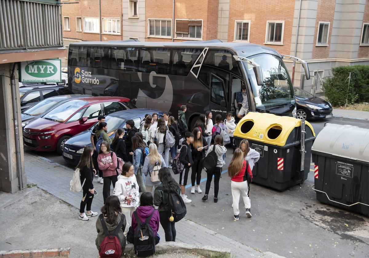 Un grupo de alumnos sale de un autobús de ruta escolar.