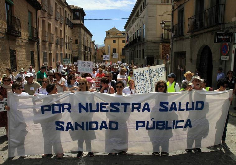 Varias personas portan una pancarta en la cabecera de la manifestación, a su paso por la calle San Agustín.