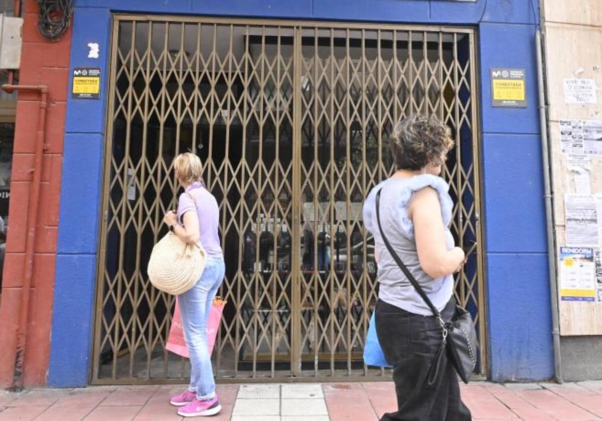 Varias personas se paran en la calle para mirar el exterior del negocio, en la Avenida Segovia, 123.