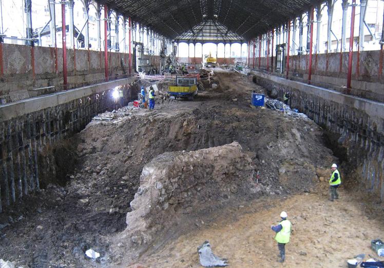 Imagen principal - Arriba, paramento relacionado con el límite norte de las construcciones del Malcocinado. Debajo, a la izquierda, conjunto de materiales arqueológicos recuperados del interior del pozo. A la derecha, excavación del pozo en el subsuelo del mercado del Val. 