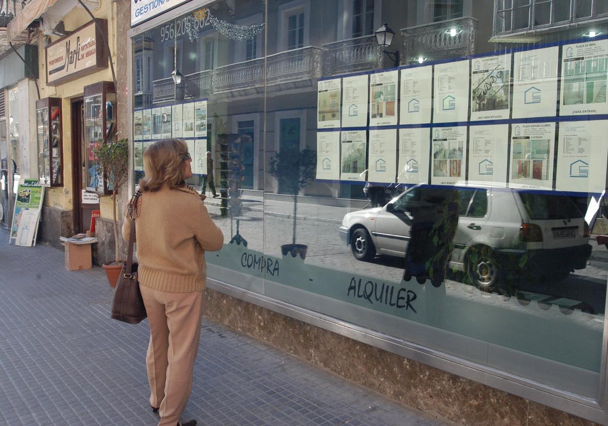 Una mujer mira el escaparate de una inmobiliaria en una imagen de archivo