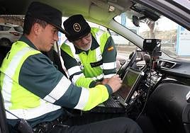 Dos agentes de la Guardia Civil manejan un radar móvil.