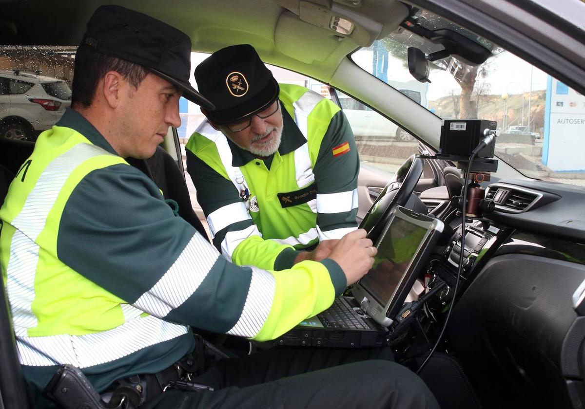 Dos agentes de la Guardia Civil manejan un radar móvil.