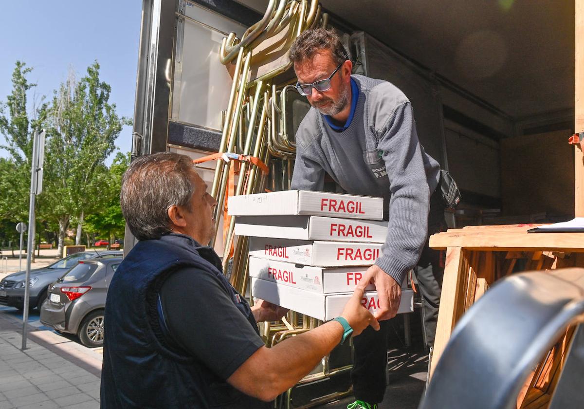 El empleado municipal Juan Ramón García recibe cinco urnas de manos de Óscar Peñas, operario de la empresa de mudanzas.