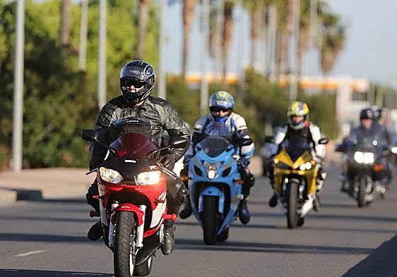 Varios motoristas circulan por una carretera.