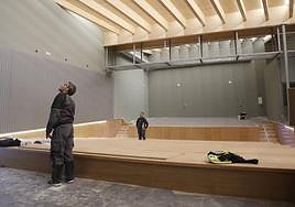 Dos trabajadores comprueban los últimos detalles en el interior del nuevo teatro.