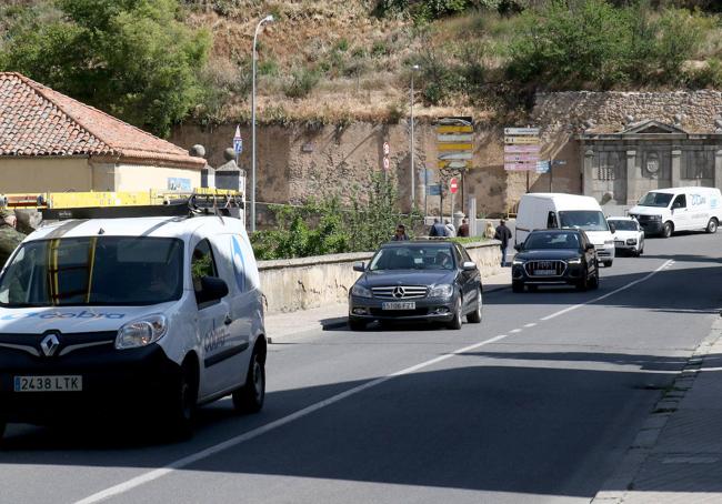 Varios vehículos circulan por el único carril de salida del barrio de San Millán.