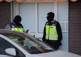 Dos agentes de la Policía Nacional en la puerta de un domicilio, en Melilla.