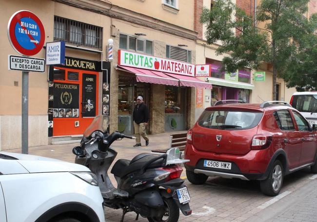 Un coche y una moto, aparcados en una plaza de carga y descarga.