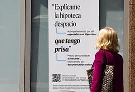 Una mujer ante un cartel bancario sobre las hipotecas.