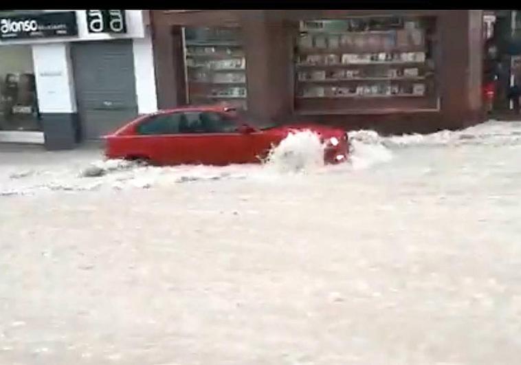 El BMW rojo arrastrado por la corriente en Molina de Segura.