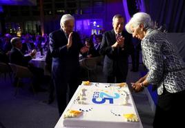 La presidenta del BCE, Christine Lagarde (d) y sus predecesores Mario Draghi (c) y Jean-Claude Trichet (i), con el pastel de celebraciçon del 25 aniversario de la institución, el miércoles.