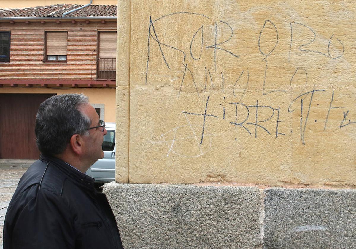 El párroco, Francisco Jimeno, observa las pintadas en la iglesia de San Lorenzo.