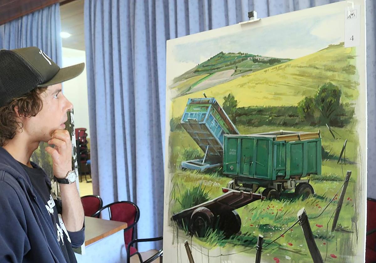 Uno de los pintores contempla uno de los cuadros.