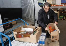 Un voluntario carga la furgoneta en la sede del Banco de Alimentos.