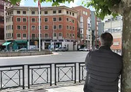 Un hombre observa el edificio desde el otro lado de la Plaza de España.