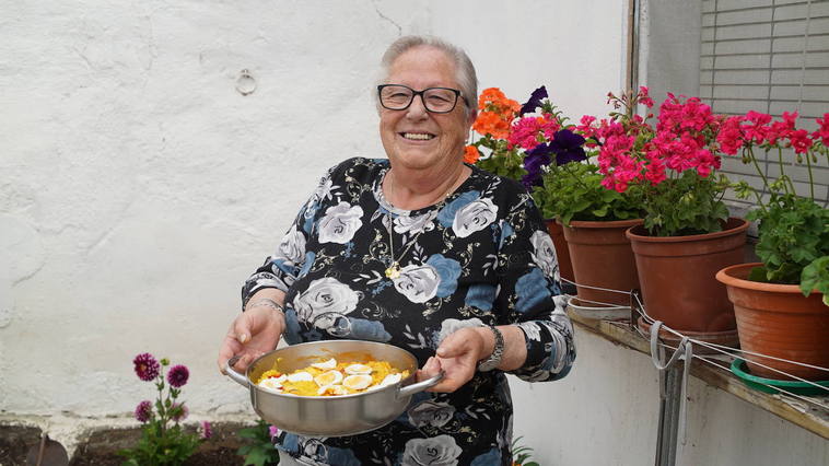 Angelines muestra orgullosa el resultado de su cocinado, un delicioso arroz con pollo.