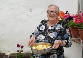 Angelines muestra orgullosa el resultado de su cocinado, un delicioso arroz con pollo.