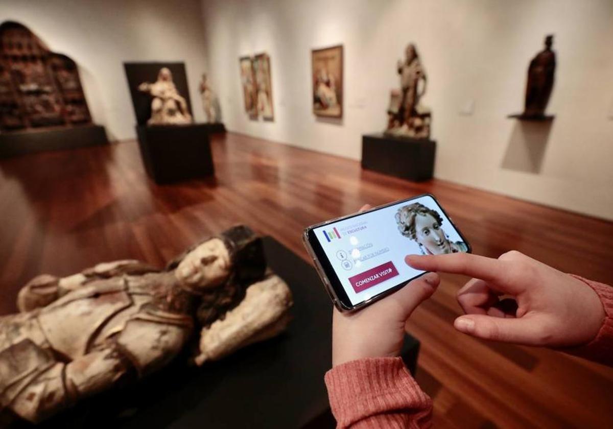 Una usuaria sigue en su aparato de telefonía la explicación sobre las tallas que se exponen en el Museo Nacional de Escultura Policromada de Valladolid.