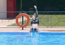 Un joven se lanza al agua en la piscina municipal Juan de Austria de Valladolid.