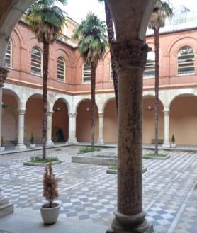 Imagen secundaria 2 - Arriba, el palacio en los años setenta del siglo XX. Debajo, a la izquierda, la plaza de La Trinidad en la actualidad y, a la derecha, el patio del interior del palacio de los Condes Benavente.