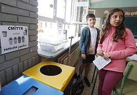 Dos alumnos de cuarto de Primaria del CEIP Alonso Berruguete, delante de un cartel para reciclar en castellano y ucraniano.
