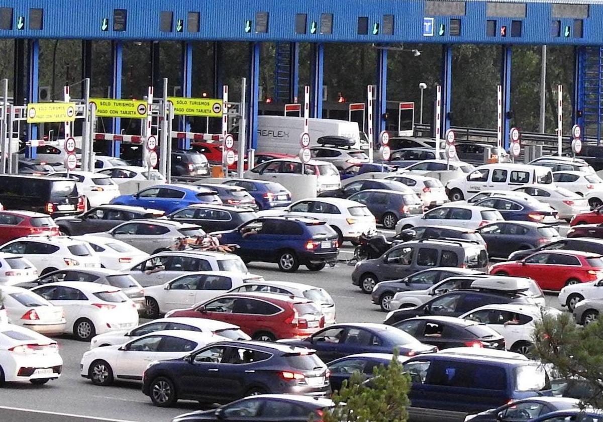 Decenas de coches, en el peaje de la AP-6 en San Rafael.